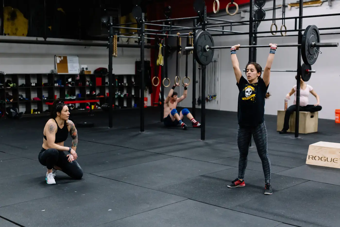 Adult athletes lifting overhead during a strength session