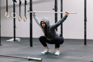 CrossFit woman athlete doing air squats to warm up for Crossfit WOD